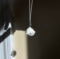 a small white cloud hanging from a string