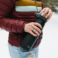 a woman holding a water bottle in the snow