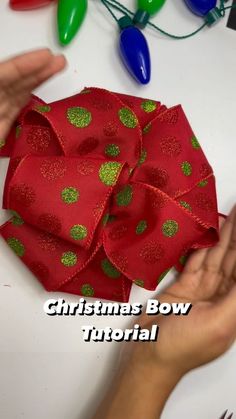 someone is making a christmas bow with red ribbon and green polka dots on the side