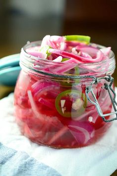 a jar filled with pickled onions on top of a table