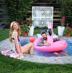 a man and woman sitting in an inflatable pool with a flamingo floater