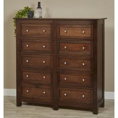 a wooden dresser with many drawers on it's sides and a potted plant on top