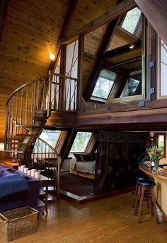 a loft with wooden walls and stairs leading up to the second floor