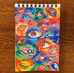 a spiral notebook with an eye painting on it