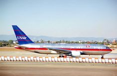 an airplane on the tarmac with mountains in the background