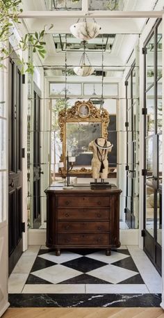 an entry way with a mirror and dresser in it