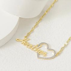 Show your love and appreciation with this stunning custom heart name pendant. This pendant features a two tone design of 10k vermeil gold and sterling silver, creating a beautiful contrast and a unique look. The pendant is shaped like a heart, with a cut-out of your chosen name in the center. The name is also plated with 10k vermeil gold, adding a touch of elegance and sparkle. The pendant comes with a 10k gold 18 inch matching chain, making it ready to wear or gift. This pendant is a perfect wa Gold Nameplate Heart Necklace For Gift, Customized Gold Heart Necklace For Mother's Day, Gold Heart Necklace With Custom Name, Gold Heart Necklace With Custom Name For Gift, Gold Heart Necklace With Name For Anniversary, Gold Heart Necklace For Anniversary Gift, Customizable Gold Heart Pendant Necklace, Gold Heart Necklace With Name For Mom, Personalized Yellow Gold Heart Pendant Name Necklace