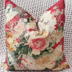 a floral pillow sitting on top of a white couch