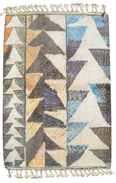 a multicolored patchwork rug with fringes on the bottom and an arrow design