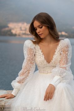 a woman in a white wedding dress sitting on a rock