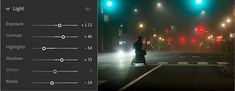 an image of a person standing in the middle of a street at night with traffic lights