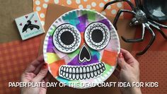 paper plate day of the dead craft for kids with a spider on it and a hand holding