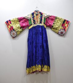 A beautiful Handmade Tribal Kutchi Dress from Afghanistan. Embellished with detailed beading and embroidery this dress has a rich floral silk skirt with gold lame, beading and embroidery. Kutchi embroidery has approximately 16 different types of stitches and styles and it is these variations that allow for the differentiation between the communities. Embroidery techniques are passed down from mother to daughter. The traditional dress of Afghanistan was very tremendous and elegant; especially the Bohemian Dress With Gold Embroidery For Ceremonial Occasions, Bohemian Dresses With Gold Embroidery For Ceremonial Events, Festive Embellished Brocade Dress, Multicolor Silk Hand-embellished Dresses, Silk Embroidered Dress For Traditional Ceremonies, Ceremonial Brocade Dresses For Festivals, Ceremonial Festival Brocade Dresses, Multicolor Hand Embellished Silk Dresses, Hand Embellished Multicolor Silk Dress