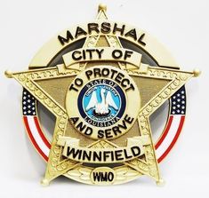 a police badge with the words marshal city of protect and serve on it's side