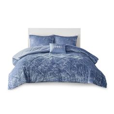 a bed with blue comforters and pillows