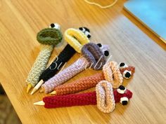 several crocheted pencils sitting on top of a wooden table