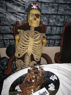 a skeleton sitting on top of a chair next to a table