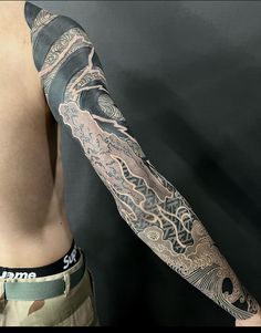 a man's arm with an intricate tattoo design on the arm and shoulder,