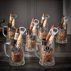 a set of six glass mugs filled with wine and cigars