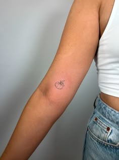 a woman's arm with a small tattoo on the left side of her arm