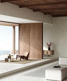 a living room filled with furniture next to a large open window overlooking the ocean and water