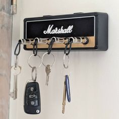 keys are hanging from a key holder on the wall next to a set of keys