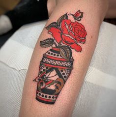 a tattoo on the arm of a woman with flowers in a vase