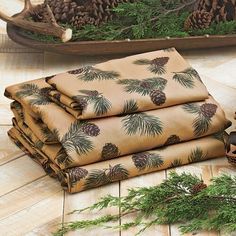 a stack of pine cones sitting on top of a wooden floor next to evergreen branches