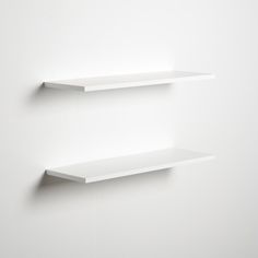 two empty white shelves on the wall