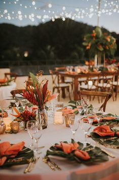 the table is set with orange napkins and place settings for an outdoor wedding reception