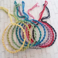 several different colored bracelets on a white surface