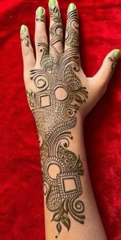 a woman's hand with henna tattoos on it