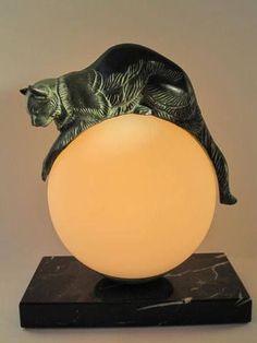 a cat sitting on top of an orange ball with its head resting on it's back