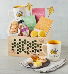 a cup of tea, cookies and honey on a plate next to a wooden box