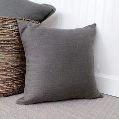 two gray pillows sitting next to each other