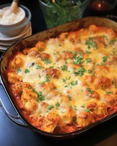 a casserole dish with meat, cheese and parsley