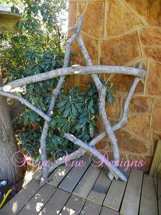 a star made out of branches sitting next to a tree