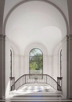 an arched doorway with wrought iron railings leads to a tiled floor that has blue and white tiles on it