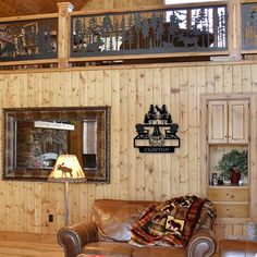 a living room with wood paneling, leather couches and deer decorations on the wall