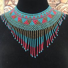 Native American hand beaded aqua maroon gold beaded necklace, Southwestern Style Jewelry Very pretty handmade aqua and maroon and gold beaded necklace that is just simply beautiful.  Measures 16 1/2 inches long by 6 inches long on the bib portion.  Excellent condition and very pretty. Artisan Beaded Turquoise Necklace, Bohemian Turquoise Bib Necklace With Colorful Beads, Turquoise Beaded Necklace With Dangling Round Beads, Southwestern Beaded Necklace With Dangling Beads For Festivals, Southwestern Style Festival Beads With Dangling Details, Southwestern Style Round Beads Jewelry For Festival, Southwestern Style Jewelry With Round Beads For Festival, Gold Turquoise Necklace With Round Beaded Details, Tiny Beads Southwestern Jewelry