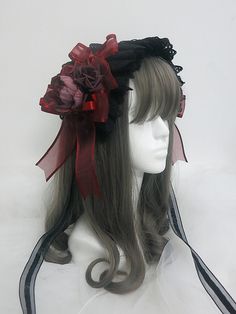 a white mannequin head wearing a black and red hat with flowers on it