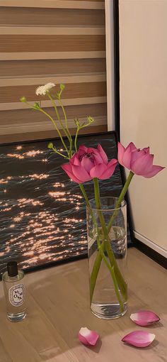 three pink flowers in a vase on a table