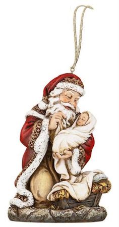 a santa clause ornament with a baby in his lap and holding the infant