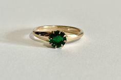 Gorgeous vintage 10k yellow gold simulated emerald ring, circa 1900s! This stylish Edwardian ring showcases a green glass simulated emerald in 'crown' style eight-prong mounting. The beautiful deep green glass is round cut. Stunning piece of fine vintage jewelry featuring May's birthstone color, circa 1900s!  ERA - Circa 1900s, Edwardian Era METAL / MATERIAL - 10k yellow gold, green glass MARKINGS / HISTORY - Inside of band is marked with Trade Mark CONDITION - Good antique condition. Glass may have chips & scratches and is securely prong set.  SIZE / MEASUREMENTS - Size: 10, Simulated emerald: 7 mm, Rise off the finger 5.1 mm, Band: tapers to 2.5 mm, Weight: 2.62 grams https://www.etsy.com/shop/LastCenturyJewels Art Deco Green Emerald Ring In 14k Gold, Victorian Emerald Ring In Yellow Gold Stamped 14k, Art Deco Emerald Ring In 14k Gold, Antique Emerald Ring In Stamped 14k Yellow Gold, Victorian Emerald Ring In 14k Yellow Gold, Heirloom 14k Gold Emerald Ring For Anniversary, Heirloom Style 14k Gold Emerald Ring For Anniversary, Heirloom Green Emerald Solitaire Ring, Victorian 14k Stamped Emerald Ring As A Gift