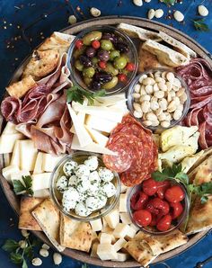 a platter filled with different types of meats, cheeses and other foods