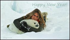 a woman laying in the snow with a panda bear