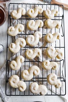 iced doughnuts on a cooling rack next to spoons and utensils