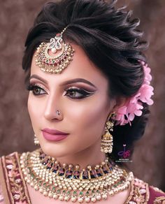 a woman wearing a bridal outfit with jewelry on her neck and headpieces