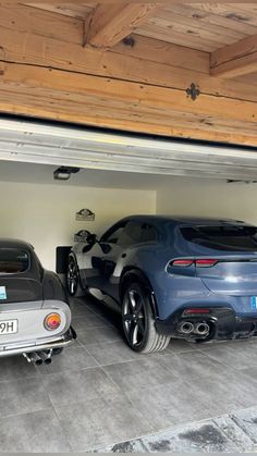 two cars are parked in the garage next to each other and there is also another car