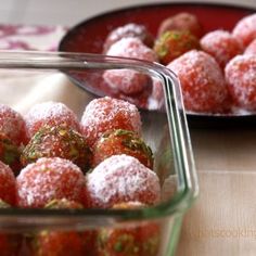 two bowls filled with powdered sugar covered strawberries next to each other on a table